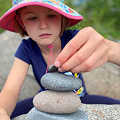 student stacking rocks to create a zen figure