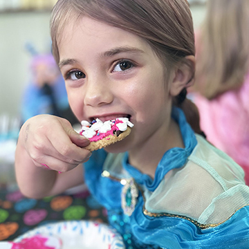 Happy student taking a bite out of a cookie