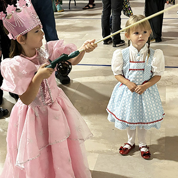 Two girls dressed up for Halloween and playing a game