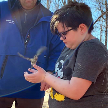 Birch Grove student holding a bird outside