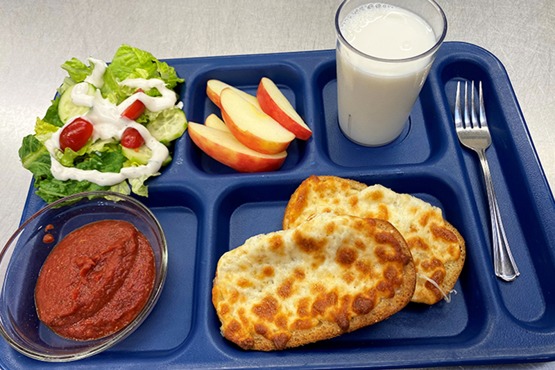 Salad, cheese pizza, sauce, apples, and milk