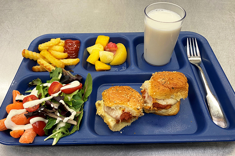 Salad, chicken parmesan sliders, french fries, fruit, and milk