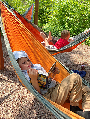 Boys on hammocks enjoying their books