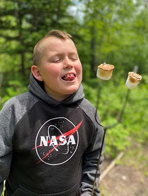 Boy licking roasted marshmallow