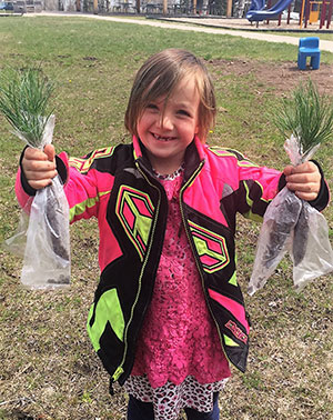 Girl with bags of plants by the playground