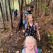 students hiking through trees