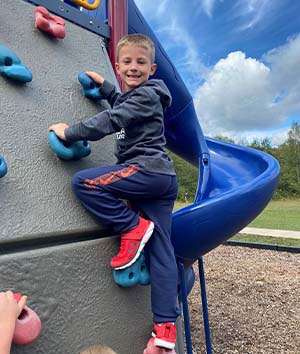 Boy climbing on playground rock wall