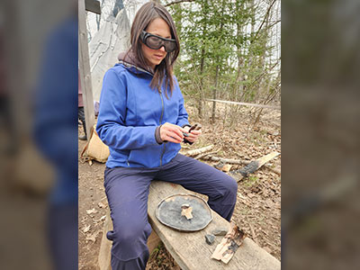 Staff member carving wood at camp